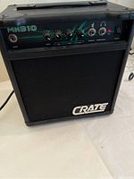 Front view of Crate MXB10 amplifier showing control knobs, input jack, speaker and headphone outputs, and power switch.