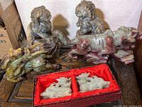 Full view of six carved stone figures arranged on a wooden surface