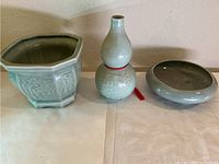 Three light green ceramic vases arranged side by side, showing overall lot contents.