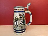 Front side view of the Avon handcrafted ceramic stein with detailed football relief art and pewter hinged lid.