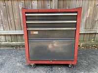 Front view of red Craftsman rolling tool chest with three drawers, locked, showing wear and chipped paint.