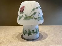Front and angled view of satin frosted glass mushroom shaped lamp with hand painted floral decoration in green, red, yellow, and blue.