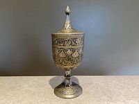Full view of the vintage Indian silver chalice with conical lidded cup, showing intricate engraving on cup and base.