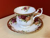 Side view of the Royal Albert Country Roses teacup showing floral pattern and gold trim.