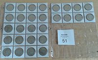 Photo showing 28 round commemorative Olympic medals in individual 2x2 holders arranged in groups, sealed in plastic