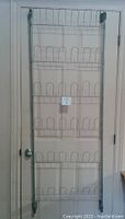 Full view of metal back of door shoe rack hanging on a closed door showing multiple shelves for shoes