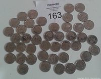Lot of 44 assorted Canadian quarters minted in 1999 laid out on a flat surface revealing obverse and reverse designs with varying condition and use marks.