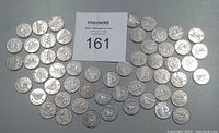 Photo showing 55 Canadian nickels ranging from 1937-dot to 1964 arranged on flat surface with auction lot number card in center