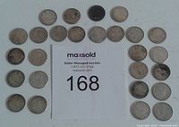 Photo shows 26 Canadian silver dimes arranged around a MaxSold lot number card. Coins appear circulated with wear and tarnish visible.