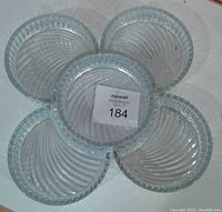 Top view of five glass bowls nested together: one large round bowl surrounded by four smaller semi-circular bowls with ribbed swirl design.