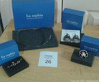 Full set of Lia Sophia jewelry including boxes: black circle necklace, earrings, ring, and pendant