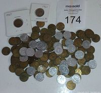A pile of approximately 123 used Ontario transport tokens in bronze and silver tone metals, some displayed in protective sleeves with dates 1961 and 1967 noted.