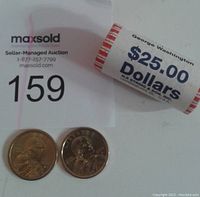 Roll of 2007 George Washington Presidential Dollars with face value $25 and two loose coins shown for scale and detail.
