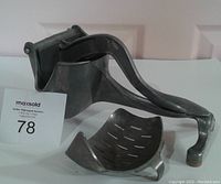 Side view of cast aluminum citrus juicer showing lever press, juicing cup, and overall shape.