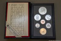 Opened case showing all seven coins in black foam including informational chart on lid.