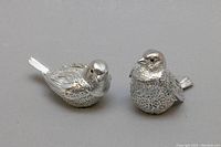 Front and side view of both bird figurines on gray background