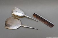 Top view of the brush, hand mirror, and comb showing the silver handles and tortoiseshell comb