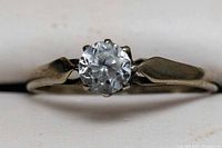 Close-up view of the 9CT gold ring with clear spinel gemstone laid flat showing the gemstone and band details.