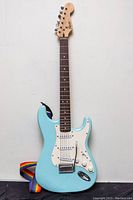 Front view of seafoam green Squier Bullet Strat electric guitar with strap attached