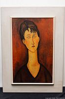 Full view of framed print showing the stylized portrait of a woman with elongated neck in reddish-brown tones.