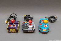 Three plug & play joystick game systems from Namco and Capcom shown side by side. Each has attached AV cables and joystick controllers.