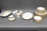 Full set at neutral background with all plates, bowls, and serving pieces stacked and arranged for overview.