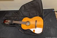 Front view of Yamaha CS40 guitar inside open gig bag