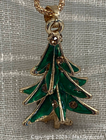 Close-up front view of the three-dimensional enamelled Christmas tree pendant with faceted rhinestone accents.