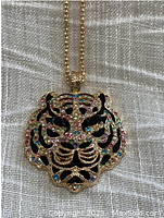 Front view of the Betsy Johnson tiger head pendant necklace with multicolored rhinestones on a gold-tone chain.