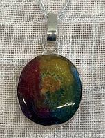 Front view of a colorful dyed banded agate stalactite pendant on a 925 sterling silver chain, showing vibrant red, yellow, green, and blue color bands and silver bail.