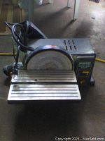 Front angle view showing sanding disc, worktable, power cord, and on/off switch
