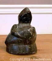 Front view of the Inuit carving showing the seated figure with hood and facial features.