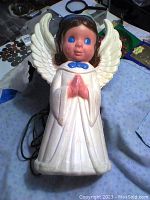 Front view of the vintage light-up plastic Christmas angel showing the figure's face, wings, and robe detail.