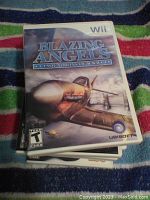 Stack of Wii video games showing cover art of 'Blazing Angels: Squadrons of WWII'