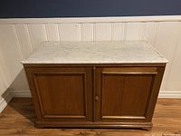 Front view of antique pine washstand with solid white marble top and two paneled doors.