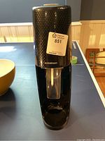 Front view of black SodaStream carbonator machine showing the nozzle and bottle holder.