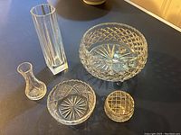 Overview of all five cut glass items arranged on a black surface showing size and cut details