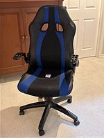Front view of black and blue upholstered gaming chair with adjustable height base and missing armrest pads.