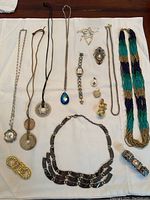 Photo showing sterling silver necklaces with various pendants, a multi-strand beaded necklace, bracelets, brooch, earrings, and Fossil watch.