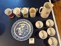 Photo showing Lord Nelson pitcher, five Royal Worcester Pershore ramekins, four blue and white patterned plates and four assorted cups