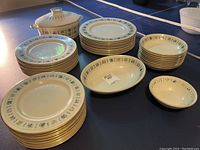 Full view of all the dinnerware pieces arranged including dinner plates, lunch plates, salad plates, small bowls, serving dish with lid, serving bowl, butter dish showing overall quantity and pattern.