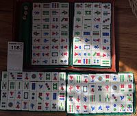 Image of Mahjong tiles arranged in multiple racks showing various suits and symbols