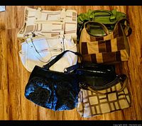 Group photo of six purses on wood floor showing varied colors and styles