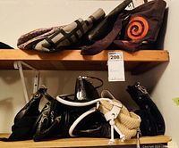 Two shelves with various women's purses showing assortment of leather and man-made materials in different styles and colors.