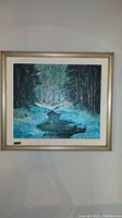 Frontal view of oil painting showing winter creek scene in silver frame