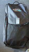 Full view of black fabric carry bag with mesh front pocket and handle for Coleman RoadTrip grill.