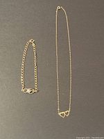 Both necklace and bracelet laid flat on black background, showing overall lot.