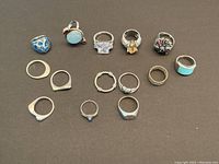 Six rows of rings arranged on black background, showing full lot.