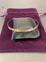 Bangle displayed on purple velvet pouch showing cutout pattern