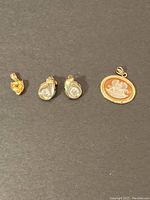 All pieces on black background: yellow gemstone pendant, teardrop earrings, oval cameo pendant